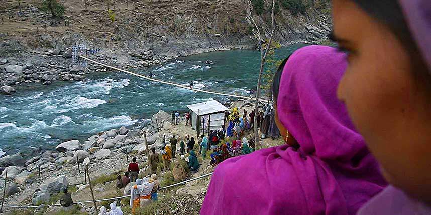 GRENSEN: Innbyggerne i den indisk-kontrollerte delen av Kashmir krysser den smale brua over elva Kishanganga, som skiller de to delene. Forh�pentligvis finner de familie og venner p� den andre siden i god behold.