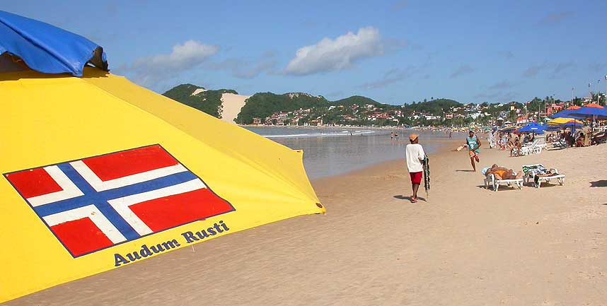 NETTO-SPONSING: Nordmannen Audun Rusti har f�tt flagget og navnet sitt p� alle parasollene han har sponset. Netto har 20 parasoller han leier ut - hovedsaklig til nordmenn i h�ysesongen.