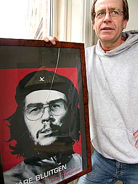 POLITISK SP�K:  K�re Bluitgen foran plakaten som viser ham inkorporert i Ernesto �Che� Guevara. - Bildet er en gave fra en av mine venner den gangen jeg fikk Kulturministeriets B�rnebogspris i 2000. Mange av mine venner er ikke s� venstreorienterte som jeg, s� det var litt sp�k med i gaven. Jeg har likevel ikke tenkt meg � g� til FN med krenkelsen, smiler K�re.