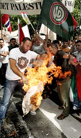 H�Y TEMPERATUR: Utenfor den barikkaderte israelske ambassaden jublet demonstrantene da det ble satt fyr p� israelske flagg og symboler.