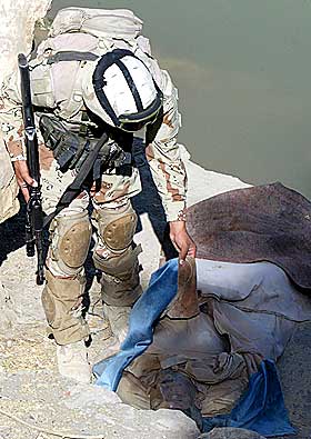 LIKFUNN: En irakisk soldat sjekker ett av de mange likene som er funnet i Bagdad de siste dagene.