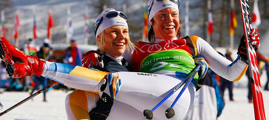GULLVINNER: Her holder Anna Dahlberg sin landskvinne Lina Andersson. De to vant lagsprinten i OL sammen, n� er Dahlberg nakkeskadd.