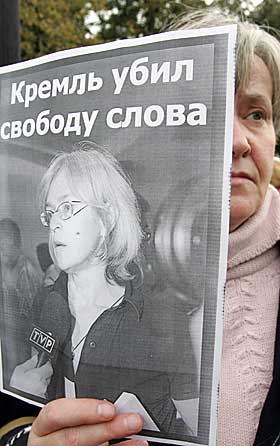 DEMONSTRERER: En kvinne holder et bilde av Politkovskaja med teksten: 