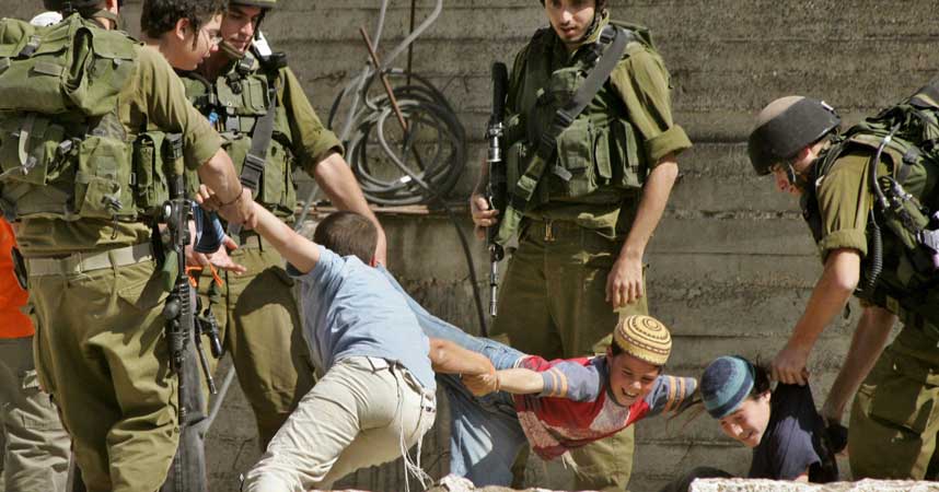 BLOKKERER FOR PALESTINERE: Det gikk hardt for seg da det israelske forsvaret skulle fjerne bosettere som blokkerte en gate brukt av palestinere n�r Kiryat Arba-bosetningen i Hebron. Det betydde lite at flere av bosetterne var barn.