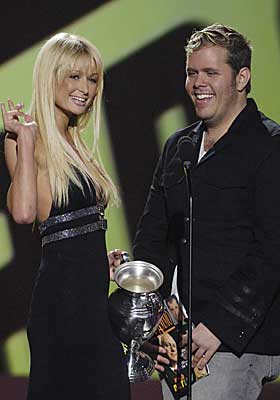 FRYKTET AV KJENDISER: Perez Hilton har selv blitt kjent etter � ha blogget om kjendiser. Her er han avbildet sammen med en av sine favoritter, Paris Hilton, som sammen med sin s�ster, f�r sv�rt snill behandling i hans blogg, sammenliknet med andre kjendiser. Perez pleier � skrible ondsinnete kommentarer eller tegne tegninger p� bilder av kjendisene. Og n� blir han saks�kt av et paparazzibyr�, for � publisere deres bilder uten tillatelse.