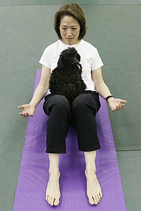 YOGA�VELSE: Suanne Natata har den lille puddelen Leilani p� fanget mens hun utf�rer en yoga�velse.