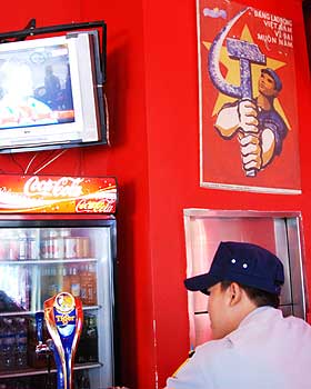 H�ND I H�ND: P� Vietnams barer lever kommunistiske propagandaplakater side om side med vestlige merkevarer og TV-programmer.