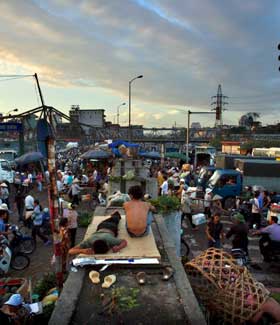 P� GAMLEM�TEN: Long Bien-markedet i Hanoi, et marked etter tradisjonelt m�nster, starter allerede f�r sola st�r opp. P� tross av supermarkeder og andre utslag av moderne kapitalisme er fortsatt det tradisjonelle markedet ryggraden i Vietnams �konomi.
