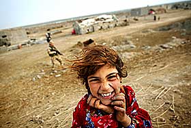 SMILER I IRAK: Barneoppdragelse er ulik verden over. Denne irakiske jenta smiler til kamera mens britiske soldater patruljerer landbyen hennes i n�rheten av Basra i det krigsherjede landet.