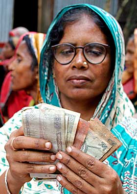 THE COLOR GREEN: Afrikas gr�nne revolusjon m� begynne med mikroforsikring og andre rettferdige �konomiske l�sninger, mener �konom Jeffrey D. Sachs. Her teller en mikrokredittkunde penger i byen Manikgan i Bangladesh.