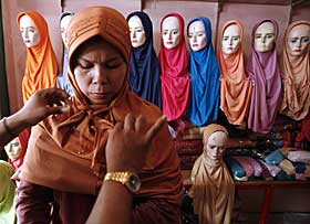 DET OMSTRIDTE SL�RET: En selger knyter en ny hijab rundt hodet til en kvinne i Jakarta, Indonesia 4. oktober i �r.