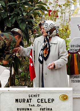 KYSSER SOLDATENS MOR: En soldat viser sin respekt for moren til en fallen kollega p� en kirkeg�rd i Istanbul.