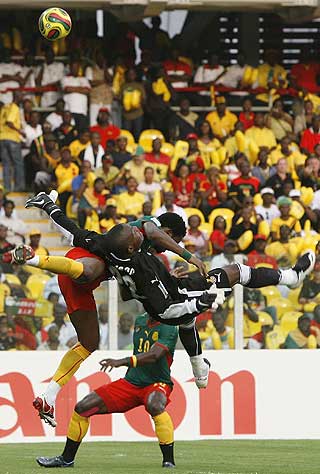 T�FFE TAK: Rigobert Song l� nede med skade etter en episode som lignet denne. Da fant lagkamerat Andr� Bikey ut at han burde dytte vekk en av b�remennene som hjalp lagkameraten. Her er det Kamerun og Barcelonas Samuel Eto'o (�verst) som st�ter sammen med Ghana m�lvakt Richard Kingson.