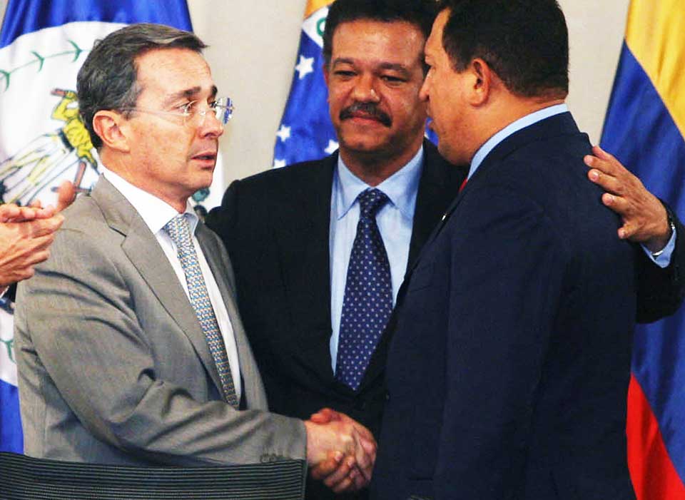 �VENNER� IGJEN: En noe motvillig Alvaro Uribe, Colombias president (t.v.), tar Venezuelas president Hugo Ch�vez (t.h.) i h�nda p� oppfordring fra Leonel Fern�ndez, president for Den dominikanske republikk og vert for toppm�tet i Rio-gruppa.