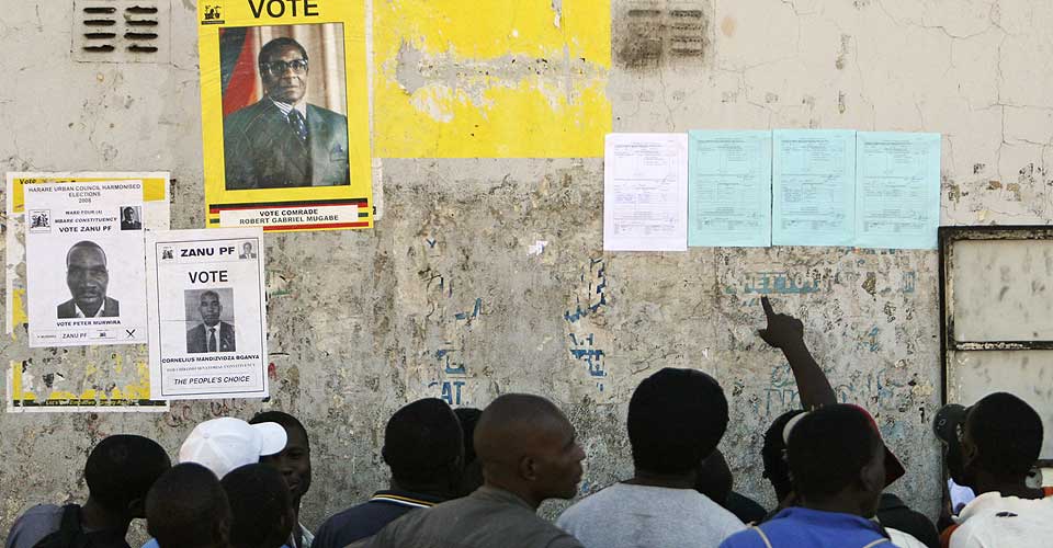 UOFFISIELLE RESULTATER: Velgere utenfor et stemmelokale i hovedstaden Harare studerer plakater som er hengt opp utenfor. Opposisjonen hevder de ligger an til klar seier.