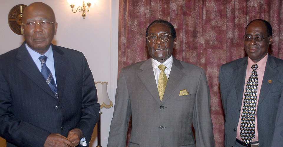President Robert Mugabe (i midten) viste seg i g�r for f�rste gang p� fem dager - uten � si noe. Her sammen med lederen for valgobservat�rene til Den afrikanske union, Ahmad Tejan Kabbah (til venstre). Han er tidligere president i Sierra Leone. Mannen til h�yre er ikke identifisert.