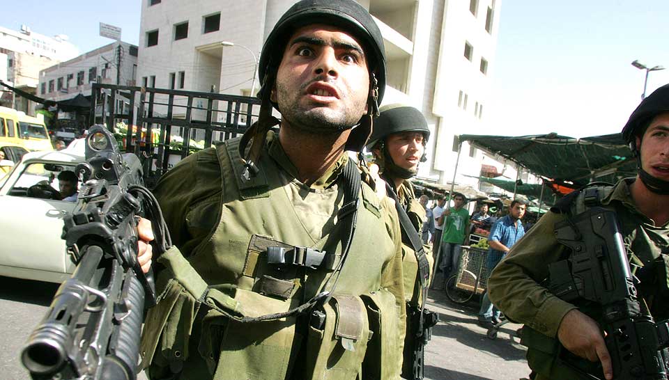 SOLDATVITNER: Her blir en fotograf utsatt for en rasende israelsk soldat under en menneskerettighetsdemonstrasjon i Hebron. I morgen offentliggj�res en rekke vitnesbyrd fra israelske soldater om systematiske overgrep mot den palestinske sivilbefolkningen beg�tt av dem selv eller medsoldater.