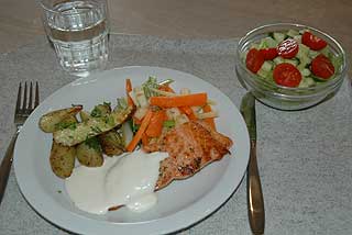 EN PORSJON:Slik ser en porsjon med laksefilet, dampede rotgr�nnsaker og urtedressing ut. Elevene skal forsyne seg selv.