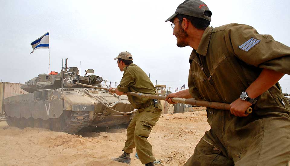 RENSKER L�PET:  Israelske soldater rensker l�pet p� tanksen etter milit�roperasjonen som fulgte angrepet p� et kj�pesenter i dag.