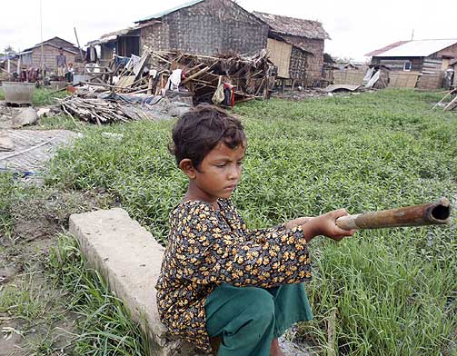 I N�D: En liten gutt sitter foran den sterkt ramponerte landsbyen der han bor. Mange barn er i faresonen hvis ikke hjelpen til Burma trappes kraftig opp.