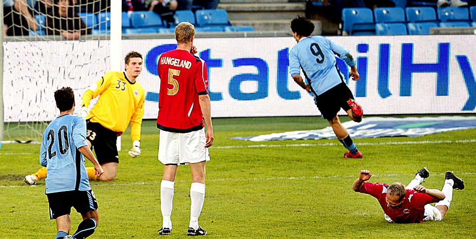 FORTVILET: Jon Inge H�iland (liggende) hamrer i Ullevaal-gresset i frustrasjon over knotten som knakk foran Uruguays f�rste scoring.