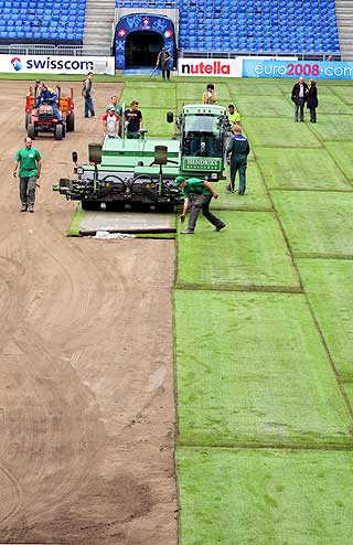 ALLE MANN I ARBEID: Banemannskapet i full sving med � legge nytt gress p� St.Jakob Stadion i Basel.
