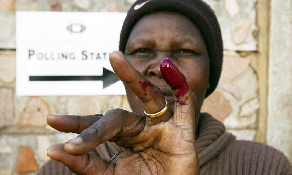 MERKET: En kvinne viser fram beviset p� at hun har stemt: en finger dyppet i r�dt blekk. Zanu-PF-bander spanet i g�r etter folk som manglet merket, for � trakassere dem og true dem til � stemme.