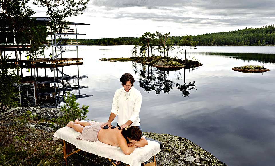 SKOGENS RO: Det nye Zen Resort & Spa (bak, til venstre) som blir bygget i R�mskog i �stfold, er Norges f�rste minimalistiske, �kologiske spa-resort. John White fra Connecticut mener det er viktig � se kropp og sinn i ett under en massasje. Her blir varme steiner lagt p� ryggen for � gi energi og f� musklene til � slappe av.