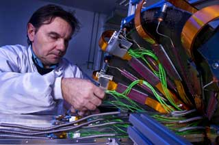 SISTE INNSPURT: En ingeni�r monterer en av de siste delene av det gigantiske puslespillet som utgj�r verdens st�rste partikkeaksellerator. Foto: CERN