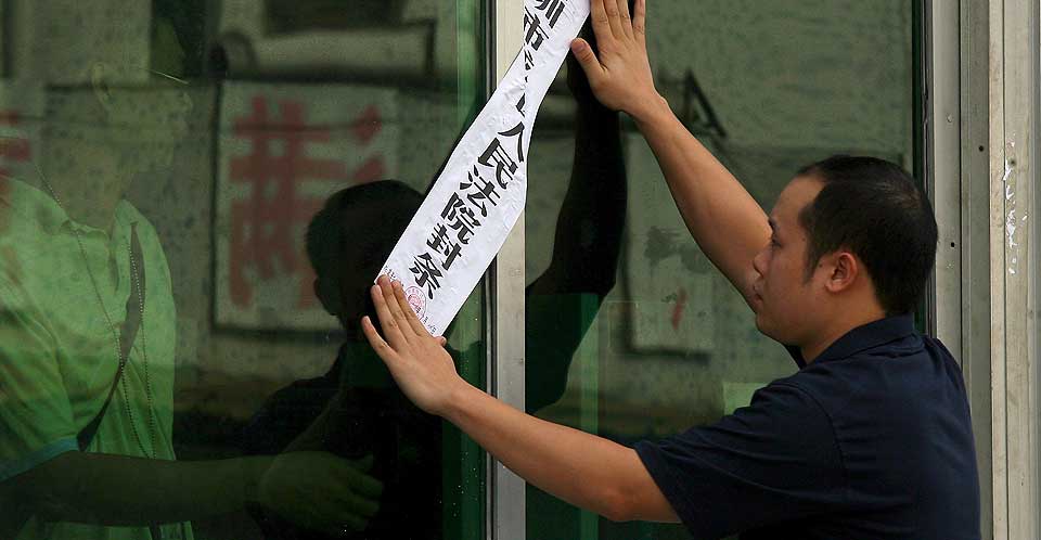 STENGER FABRIKKER: En mann forsegler nok en fabrikk, som har m�tte stenge p� grunn av �konomiske nedgangstider i Shenzhen i Guangdong-provinsen, s�r i Kina. De siste to ukene har fem fabrikker i omr�det stengt og mer enn 10 000 mennesker har mistet jobben.