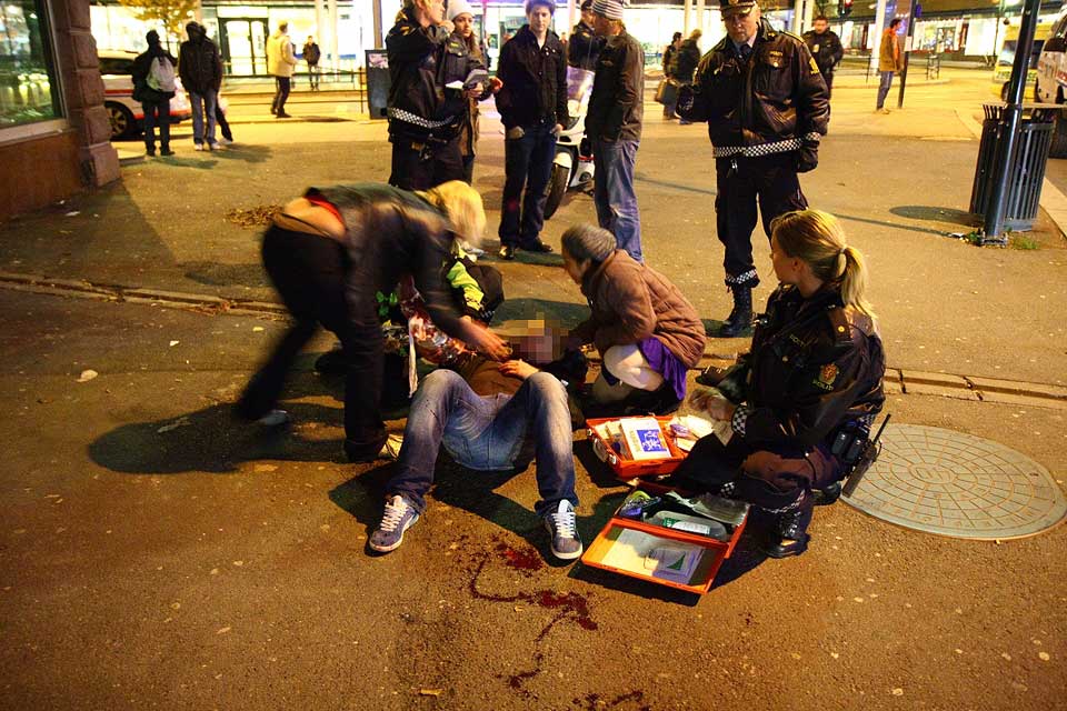 STUKKET I HALSEN: Et av knivdesperadoens ofre ligger skadet p� bakken n�r Gunerius i Storgata. Minst tre personer ble knivskadd f�r politiet klarte � p�gripe mannen.