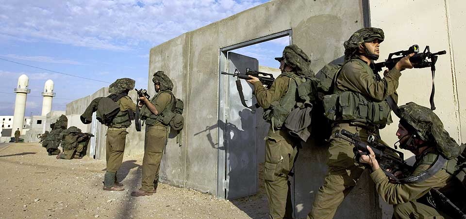 TRENER P� N�RKAMP: Flere tusen israelske reservesoldater har blitt kalt inn p� grunn av krigen i Midt�sten. N� er det besluttet at de skal delta i bakkekampene som foreg�r inne p� Gazastripen. Dette bildet er tatt fra en treningsleir tidligere i uken, hvor soldater beveger seg i typiske boligomr�der man finner i krigssonen.