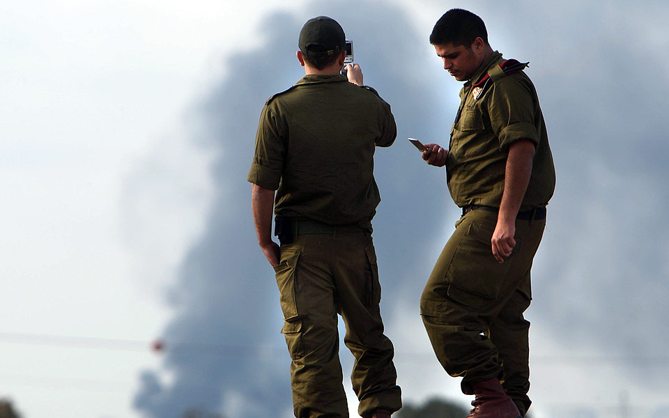  TIL MINNEBOKA:  To israelske soldater tar bilder med mobilen etter at en bombe har sl�tt ned p� Gazastripen.