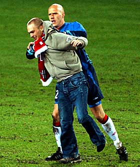 4: Frode Olsen geleider tilskueren av banen. I alle fall �n nordmann ville sl�ss i g�r ... Etter kampen �nsket keeperen ikke � fortelle hvorfor han gjorde som han gjorde.