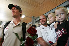 HYLLET: OL-vinner Andreas Thorkildsen kom hjem til Norge mandag. Her st�r han sammen med trener �smund Martinsen og hans s�nner Joakim og Ruben (t.h.) p� Gardermoen. Familie, venner og kollegaer i sportsklubben Vidar hadde m�tt opp for � ta imot spydkasteren.